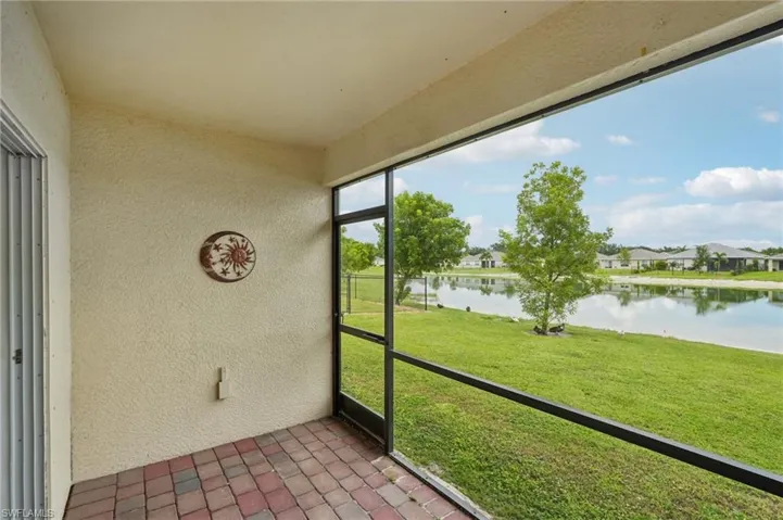 Unfurnished sunroom featuring a water view and a residential view