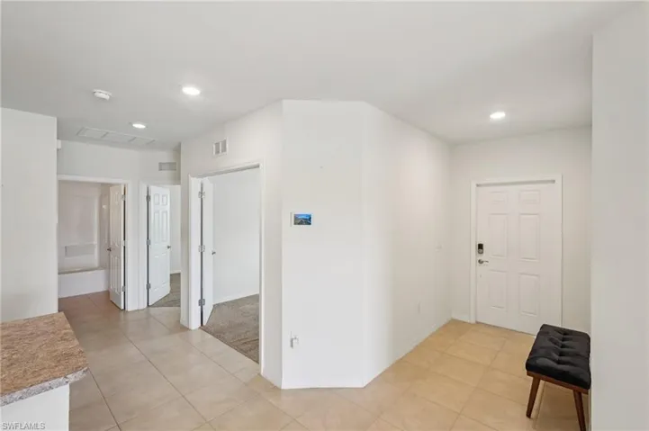 Hall featuring recessed lighting and light tile patterned floors
