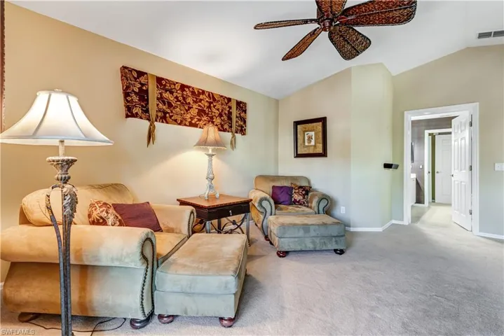 Sitting room with vaulted ceiling, carpet floors, and ceiling fan