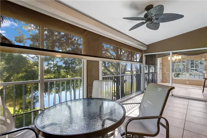 Sunroom with a water view, vaulted ceiling, tile patterned floors, and a chandelier