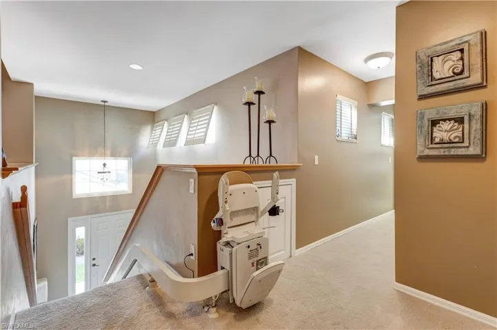Hallway featuring an upstairs landing, carpet floors, and recessed lighting
