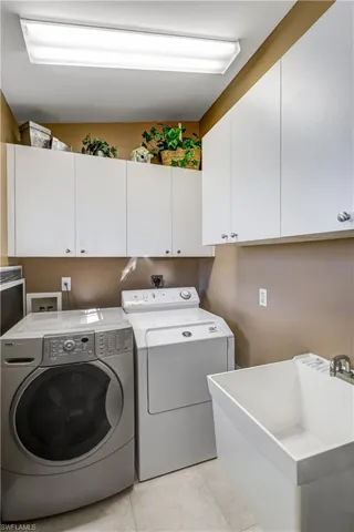 Laundry room featuring washing machine and dryer and light tile patterned floors