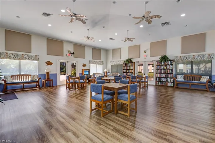 Community Room, library, with kitchen and a high ceiling, wood finished floors, recessed lighting, and french doors