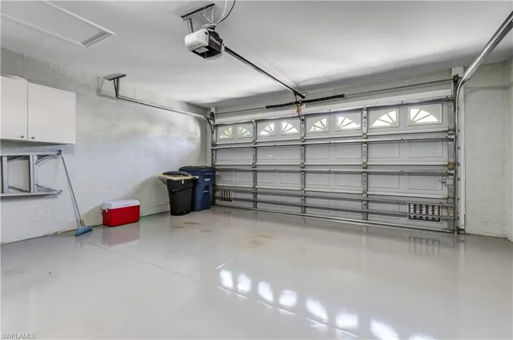 Garage featuring a textured wall and a garage door opener