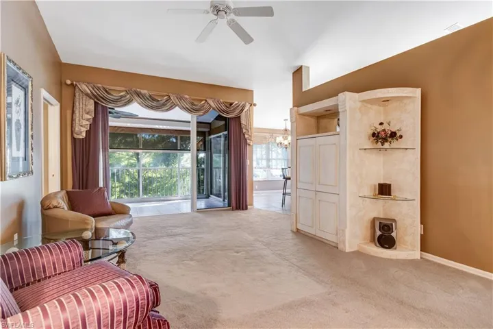 Sitting room with light carpet, a chandelier, and a ceiling fan