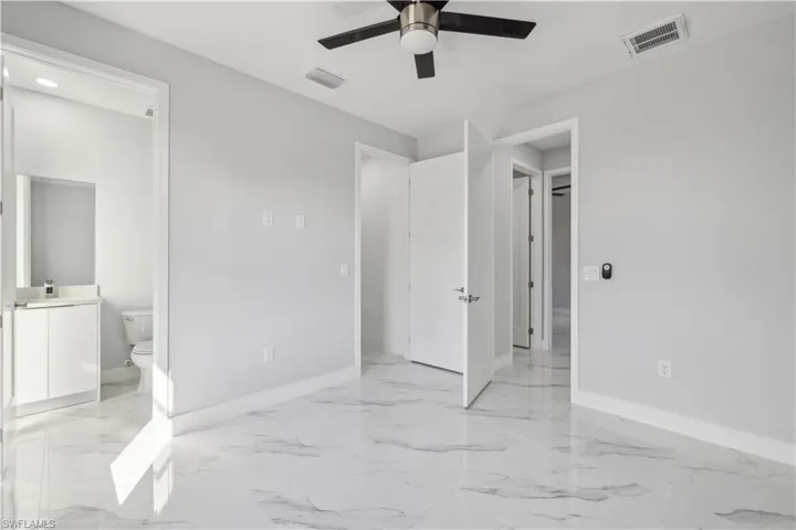 Bedroom featuring ceiling fan and ensuite bathroom