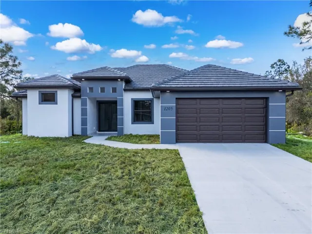 View of front of home featuring a garage and a front lawn