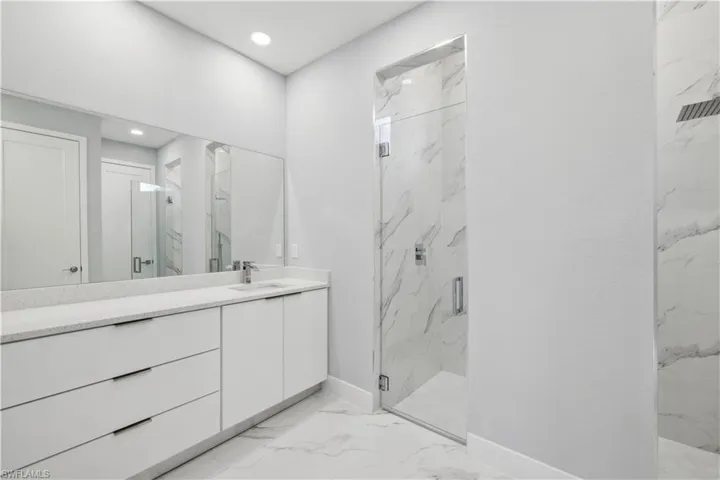 Bathroom featuring vanity and a shower with shower door