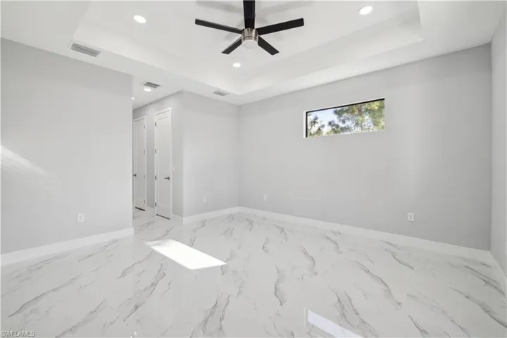 Empty room with a raised ceiling and ceiling fan