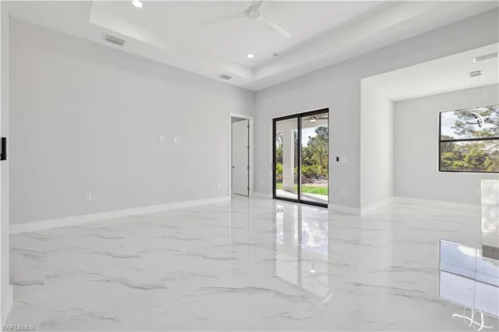 Unfurnished room with a tray ceiling and ceiling fan