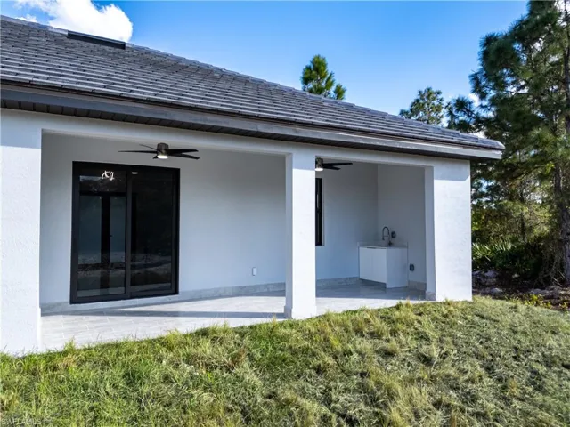Back of property with ceiling fan and a patio area