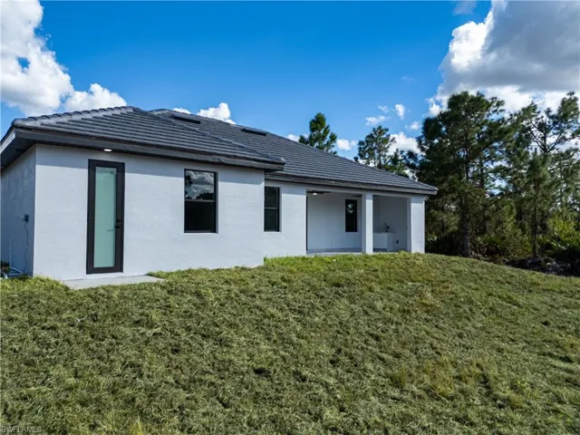 Back of property with a lawn