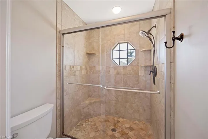 Bathroom featuring toilet and a stall shower