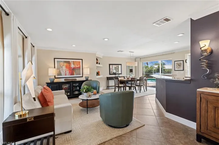 Tiled living room featuring recessed lighting and crown molding