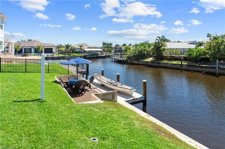 Dock area with a yard, fence, a water view, and a residential view