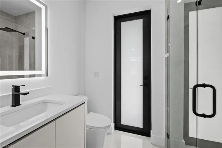 Bathroom featuring vanity, toilet, and walk in shower