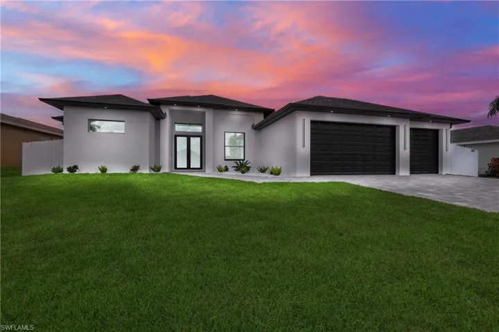 View of front facade featuring a yard and a garage