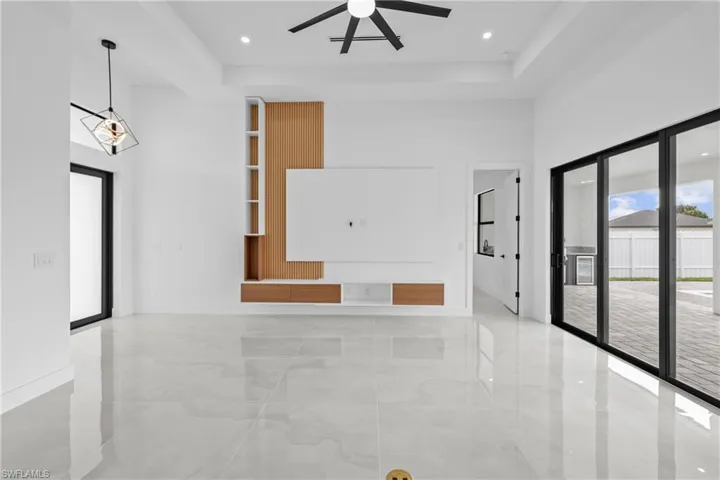 Unfurnished living room featuring ceiling fan