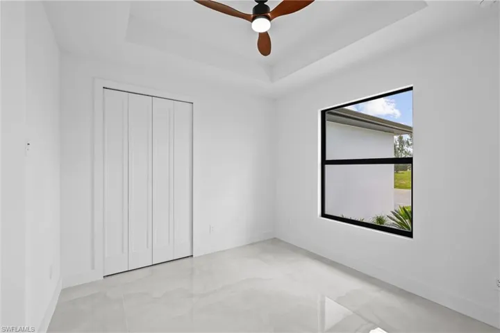 Unfurnished room with a raised ceiling and ceiling fan