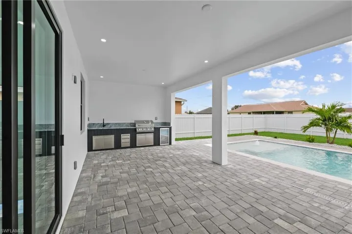 View of pool with exterior kitchen, a patio area, area for grilling, and sink