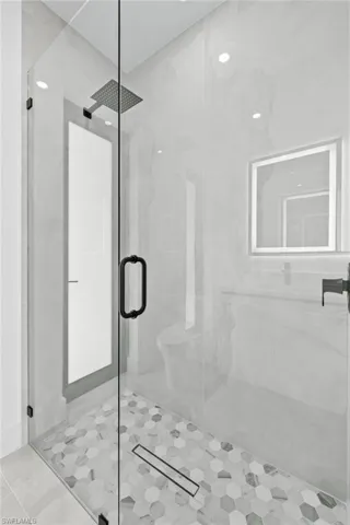 Bathroom with an enclosed shower and tile patterned floors