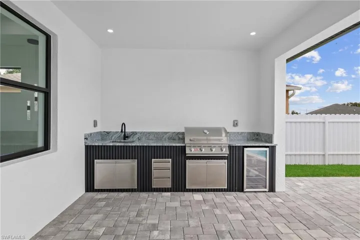 View of patio / terrace featuring a grill, beverage cooler, an outdoor kitchen, and sink