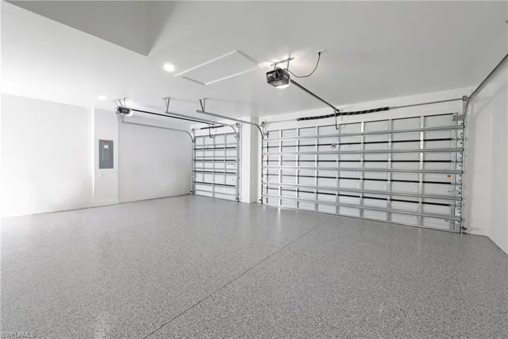 Garage featuring a garage door opener and electric panel