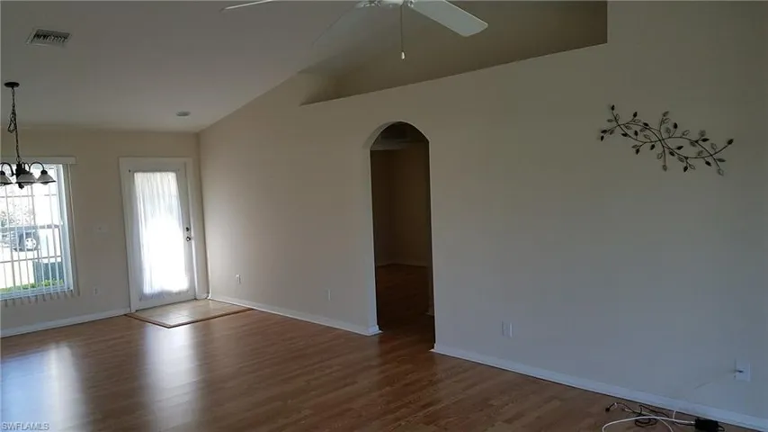 Vaulted ceiling with a ceiling fan, wood-finish flooring, recessed lighting, and an arched doorway