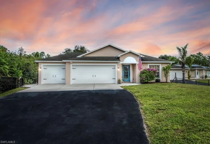 Single story home with a lawn and a 3 car garage
