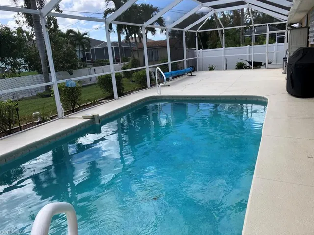 View of swimming pool with a patio area and a lanai