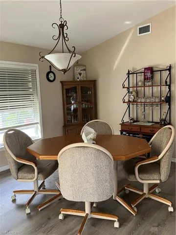 Dining area with hardwood / wood-style floors and vaulted ceiling