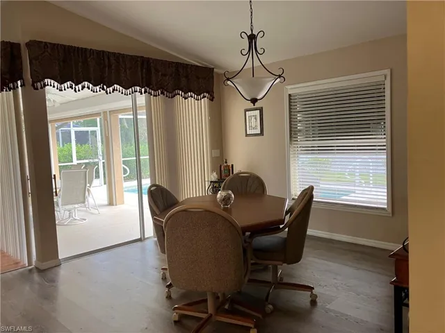 Dining area with lofted ceiling and wood-type flooring