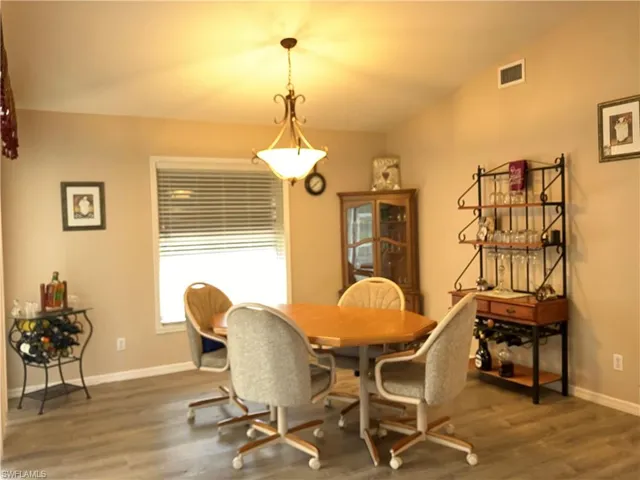 Dining room featuring vaulted ceiling and dark hardwood / wood-style flooring
