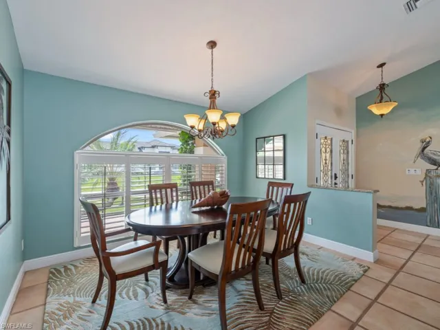 Dining area featuring lofted ceiling, a chandelier, and light tile patterned floors