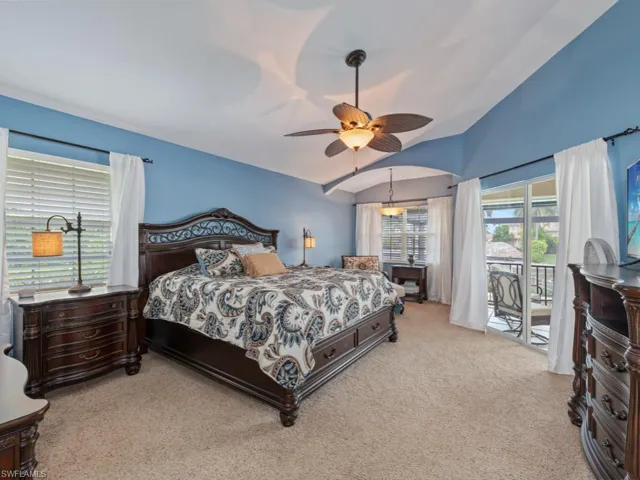 Bedroom featuring lofted ceiling, access to outside, carpet flooring, and ceiling fan