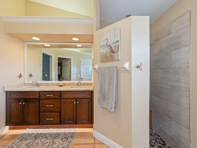 Bathroom with double vanity and light tile patterned floors