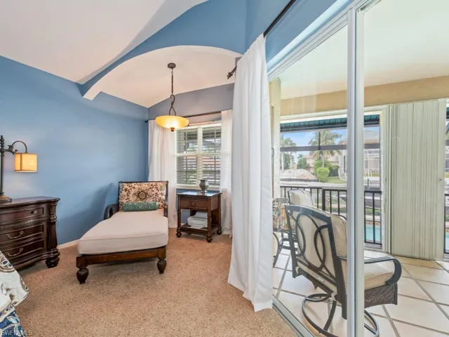 Sitting room featuring carpet, arched walkways, and lofted ceiling