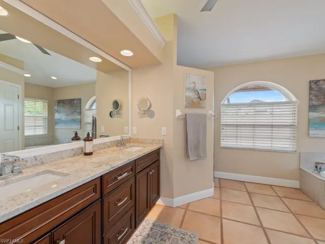 Bathroom featuring a ceiling fan, double vanity, a bath, light tile patterned floors, and recessed lighting