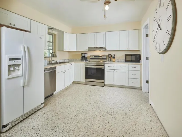 Kitchen features shaker cabinets and quartz countertops with ample storage.