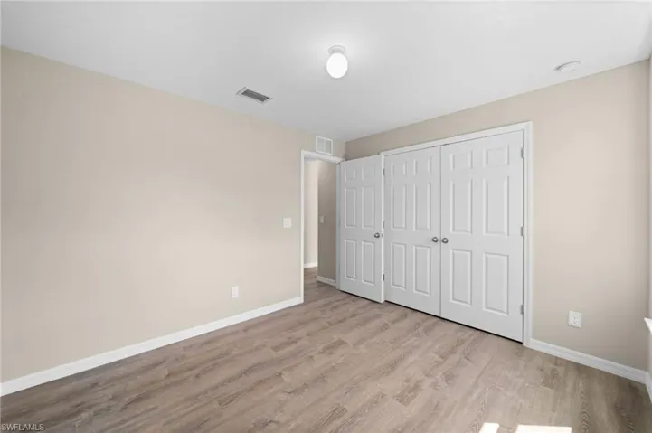 Unfurnished bedroom featuring light hardwood / wood-style floors and a closet
