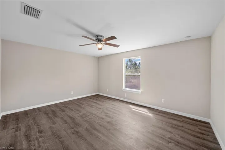 Spare room with ceiling fan and dark hardwood / wood-style floors