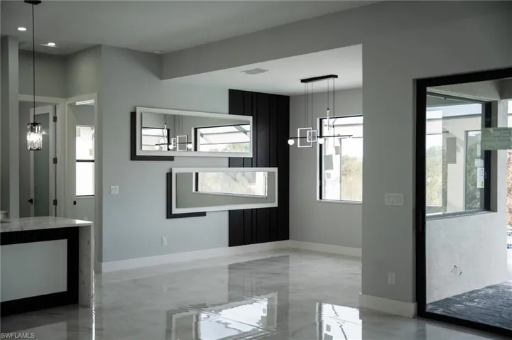 Unfurnished dining area with a chandelier and light marble finish flooring
