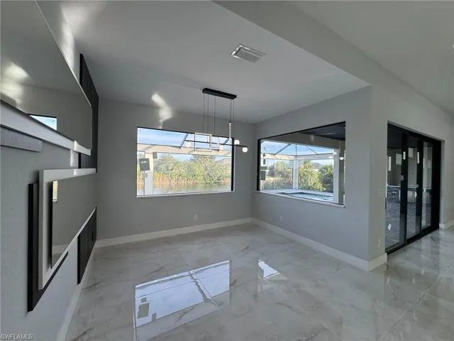 Unfurnished dining area featuring light marble finish flooring and baseboards