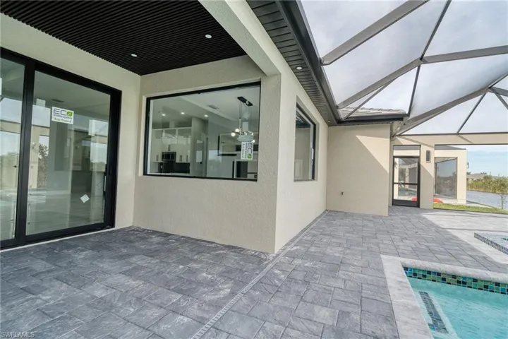 View of patio with a sunroom, an outdoor pool, and a lanai