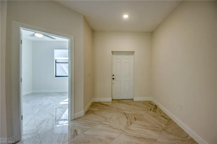 Entrance foyer with baseboards and light marble finish flooring
