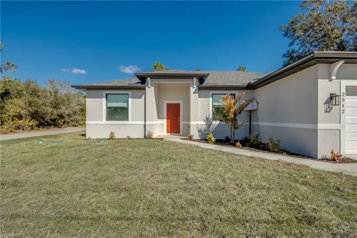 View of front of property featuring stucco siding, a front lawn, a shingled roof, and an attached garage