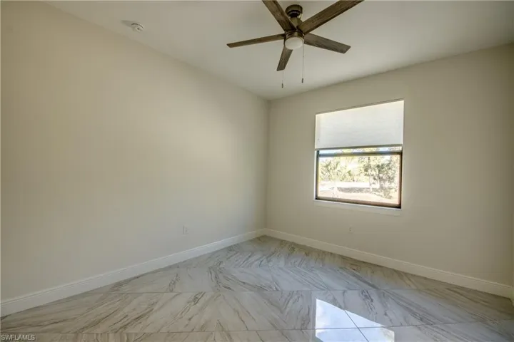Spare room featuring a ceiling fan and light marble finish flooring