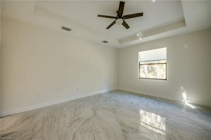 Empty room with a tray ceiling and ceiling fan