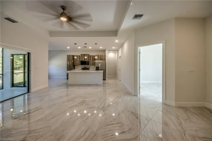 Unfurnished living room with ceiling fan and recessed lighting