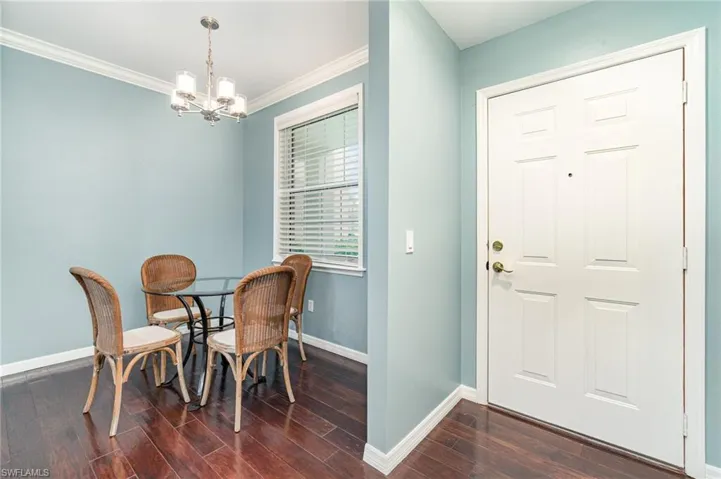 Dining room/kitchen nook,dark wood-style floors, and crown molding